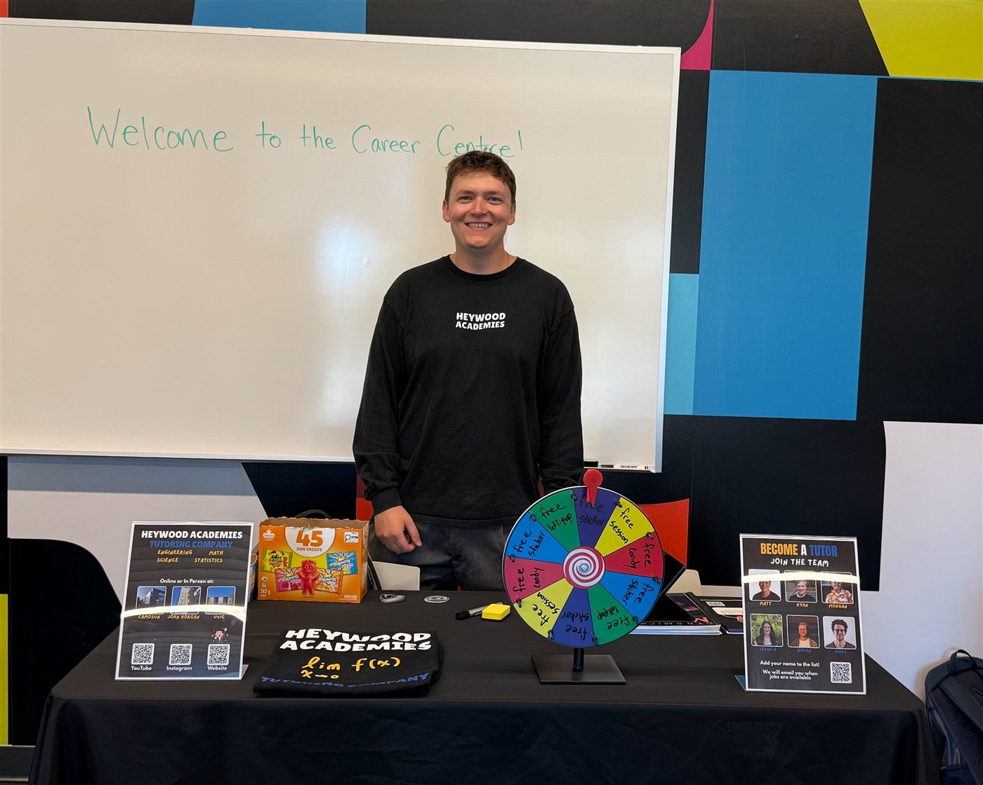 The Heywood Academies booth at Campus Connect, with a prize wheel, candy, stickers, and sign-up sheets