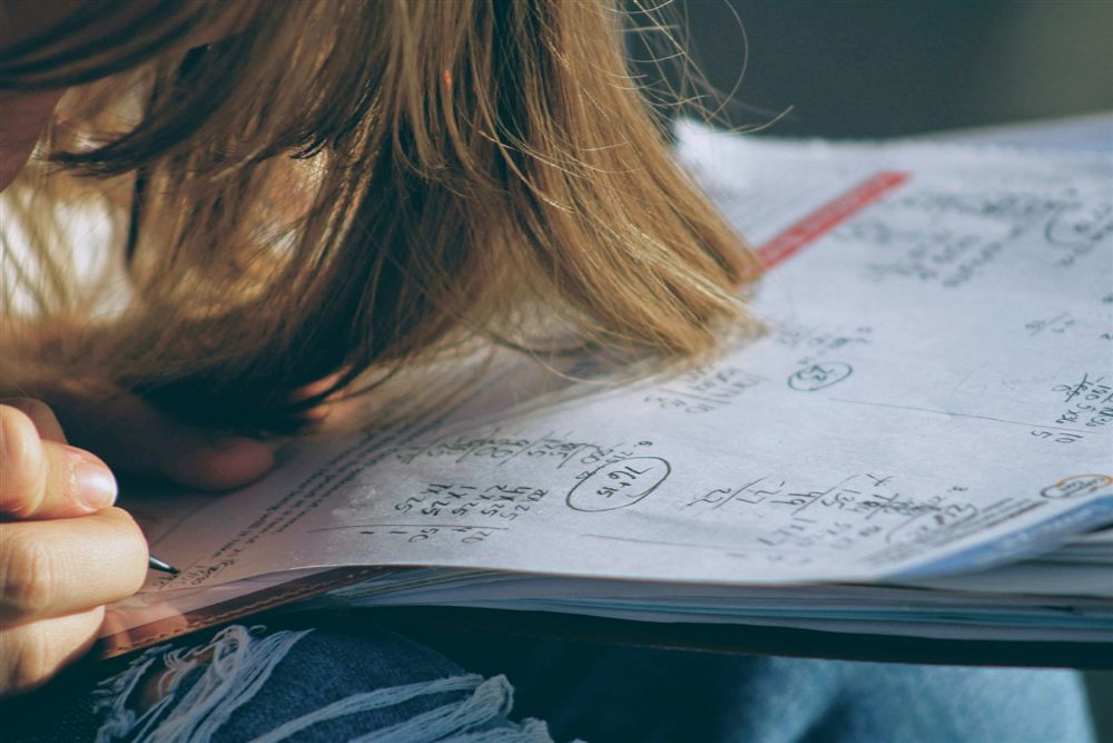 Grade 10 student working through handwritten math problems while preparing for the Numeracy Assessment.