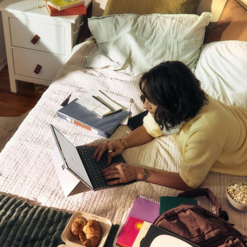 A student studying with notes and a laptop