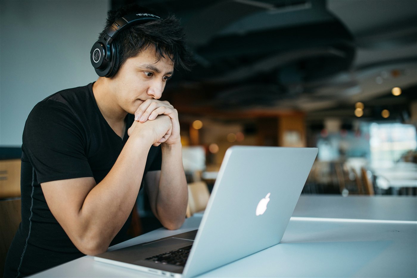A student wearing headphones focused on a laptop