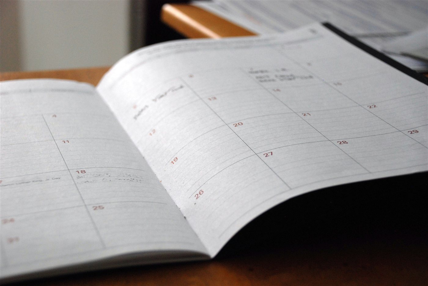 An open monthly planner on a wooden desk