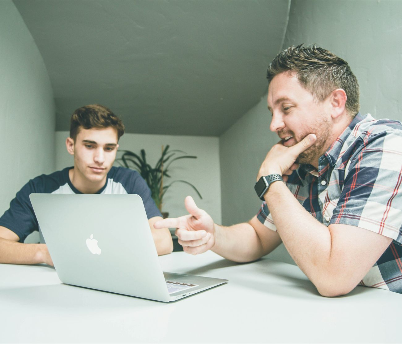A tutor working through a problem with a student side by side at a table