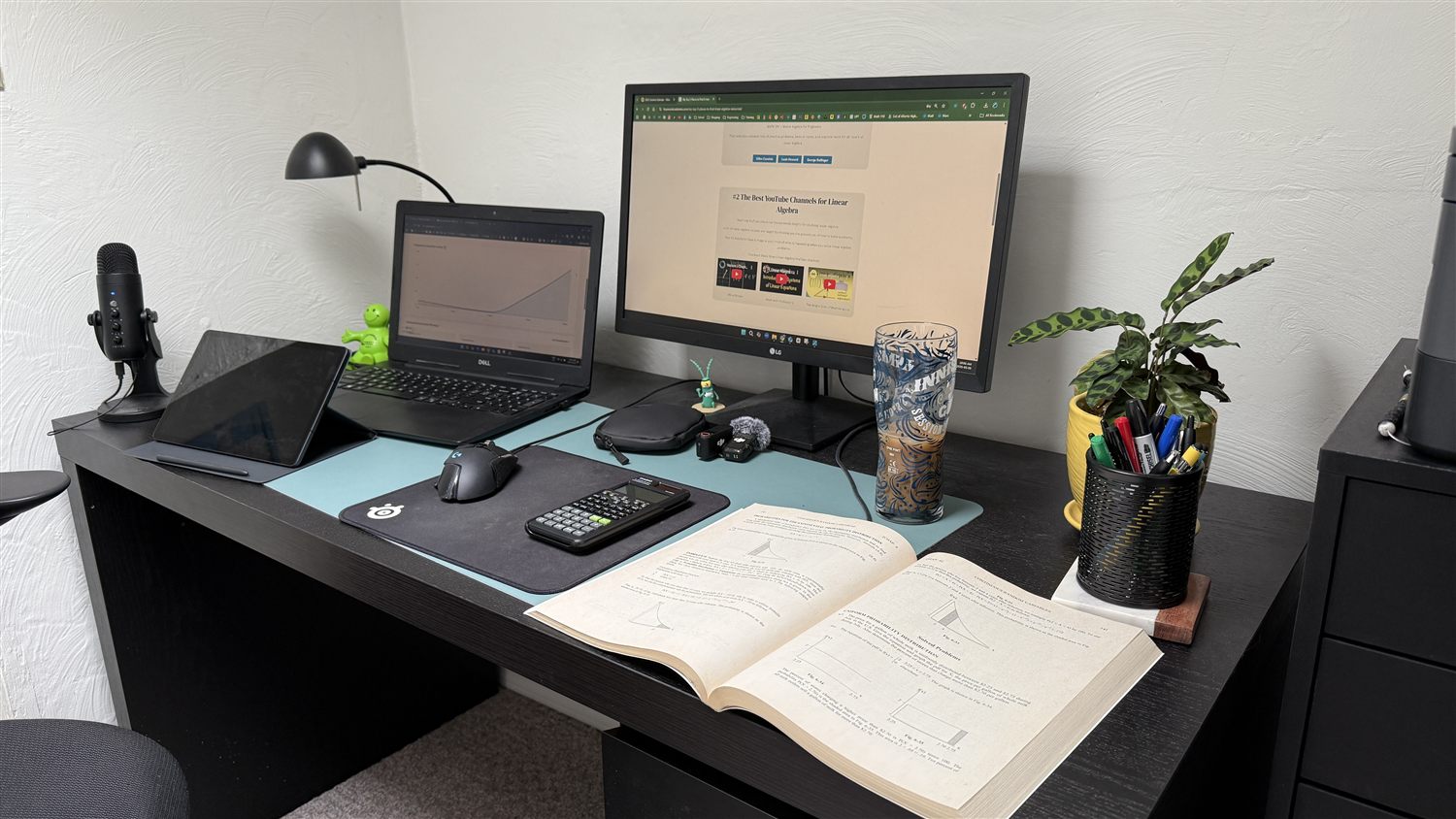 A study desk set up with practice problems and worked solutions