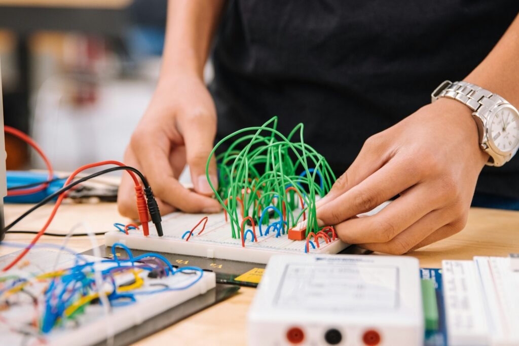 Hands Wiring Prototype On Work Bench